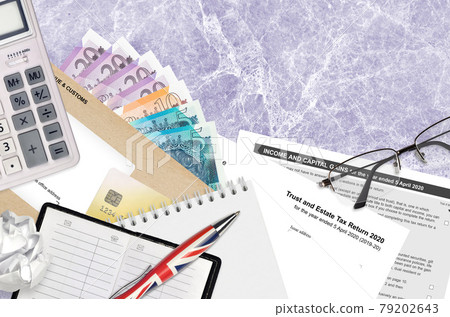 English Tax form sa900 Trust and estate tax return 2020 from HM revenue and customs lies on table with office items. HMRC paperwork and tax paying process in United Kingdom English Tax form sa900 Trust and estate tax return 2020 from HM revenue and customs lies on table with office items. HMRC paperwork and tax paying process in United Kingdom 79202643