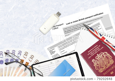 English form LS01 Lost or stolen british passport notification from HM passport office lies on table with office items. UK passport paperwork English form LS01 Lost or stolen british passport notification from HM passport office lies on table with office items. UK passport paperwork 79202648