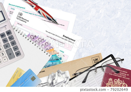 English Tax form sa102 Employment by HM revenue and customs lies on table with office items. HMRC paperwork and tax paying process in United Kingdom 79202649