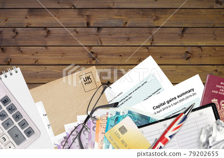 English Tax form sa107 Capital gains summary from HM revenue and customs lies on table with office items. HMRC paperwork and tax paying process in United Kingdom English Tax form sa107 Capital gains summary from HM revenue and customs lies on table with office items. HMRC paperwork and tax paying process in United Kingdom 79202655