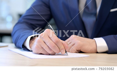 Close up of Hands of Middle Aged Businessman Writing on Paper  79203082