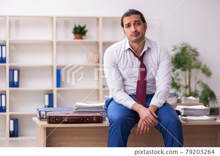 Extremely tired young male employee in the office Extremely tired young male employee in the office 79203264