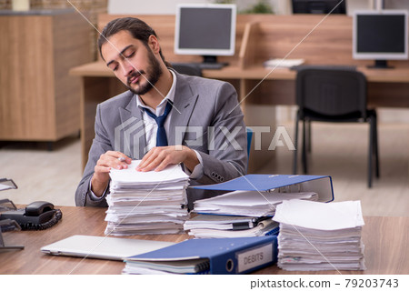 Young businessman employee unhappy with excessive work in the of Young businessman employee unhappy with excessive work in the of 79203743