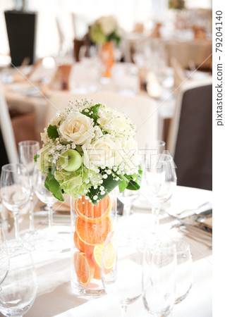 A flower arrangement for a refreshing and cute wedding reception that incorporates fruits 79204140