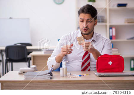 Young male employee suffering at workplace Young male employee suffering at workplace 79204316