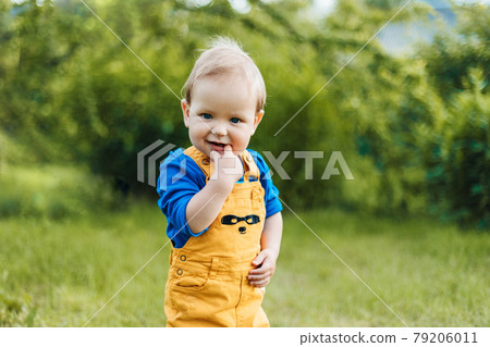 Portrait of a smiling boy in a summer park park or garden. Blurred background, space for text 79206011