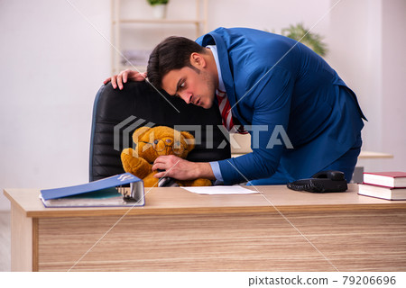 Young male employee and his toy bear boss in funny concept Young male employee and his toy bear boss in funny concept 79206696