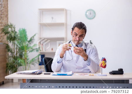 Young male doctor cardiologist working in the clinic Young male doctor cardiologist working in the clinic 79207312