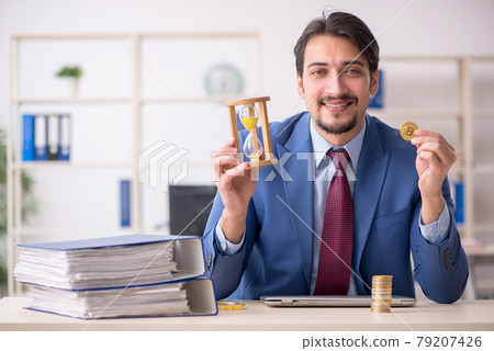 Young man earning money via Internet in time management concept Young man earning money via Internet in time management concept 79207426