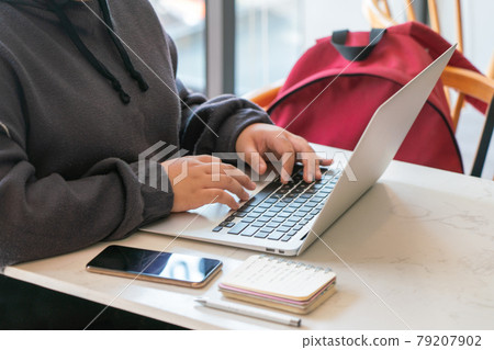 Woman hand in hoodie working on laptop Woman hand in hoodie working on laptop 79207902
