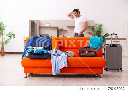 Young man student preparing for trip at home 79208012