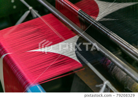 A classic weaving machine and silk thread that preserves tradition 79208329