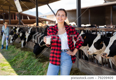 Young woman farmer working at dairy farm 79209409