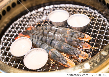 Japanese barbecue restaurant. Shrimp and scallops are heated on the grilled net. Japanese barbecue restaurant. Shrimp and scallops are heated on the grilled net. 79210182