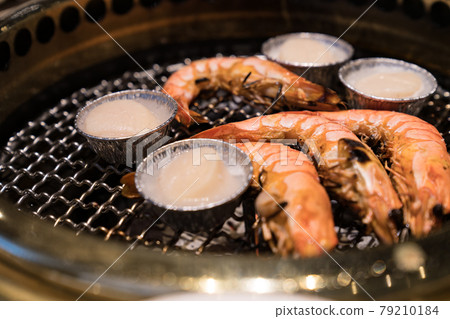 Japanese barbecue restaurant. Shrimp and scallops are heated on the grilled net. Japanese barbecue restaurant. Shrimp and scallops are heated on the grilled net. 79210184