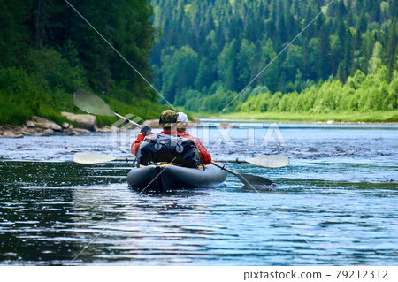 couple in a two-seater kayak rafting down the river among the mountains 79212312