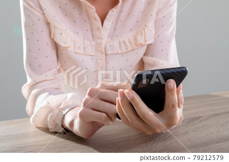 Midsection of caucasian businesswoman using smartphone, isolated on grey background 79212579
