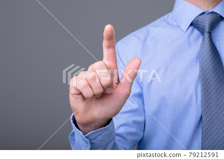 Midsection of caucasian businessman touching virtual interface, isolated on grey background 79212591