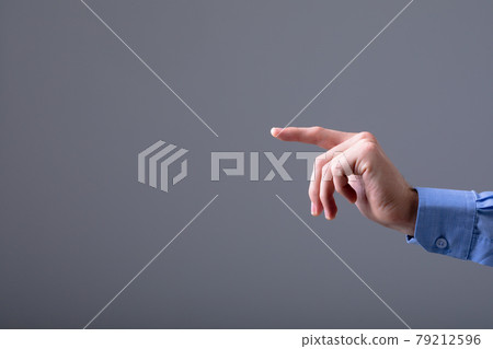 Midsection of caucasian businessman pointing with his finger, isolated on grey background 79212596