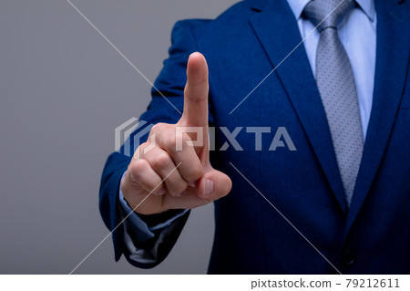 Midsection of caucasian businessman touching virtual interface, isolated on grey background 79212611