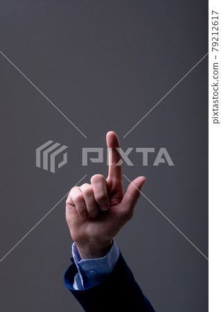 Midsection of caucasian businessman touching virtual interface, isolated on grey background 79212617