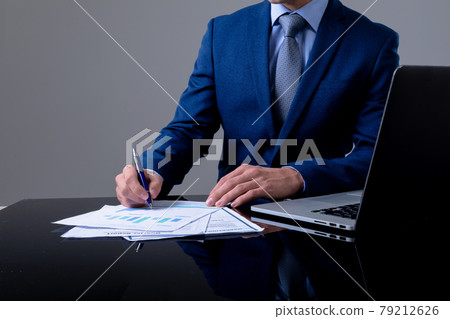 Midsection of caucasian businessman using laptop and taking notes, isolated on grey background 79212626