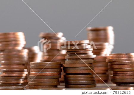 Close up of piles of coins on table, isolated on grey background 79212635