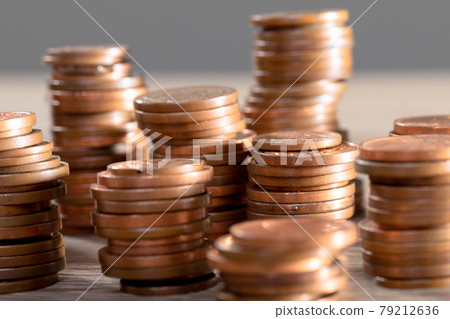 Close up of piles of coins on table, isolated on grey background 79212636
