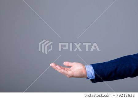 Midsection of caucasian businessman reaching his hand, isolated on grey background 79212638