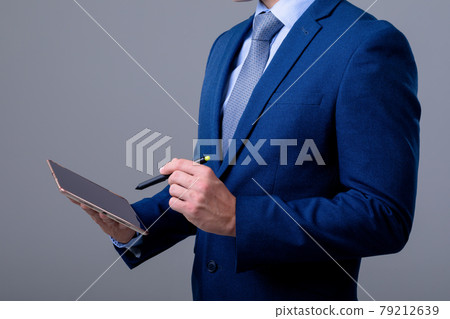 Midsection of caucasian businessman using digital tablet, isolated on grey background 79212639