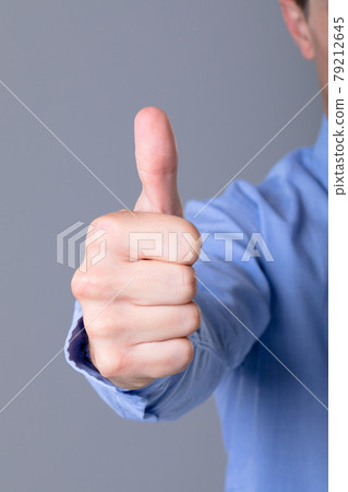 Midsection of caucasian businessman with thumb up, isolated on grey background 79212645
