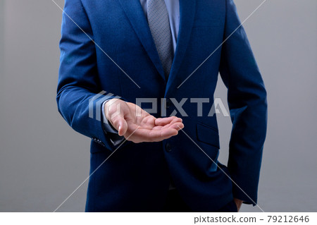 Midsection of caucasian businessman reaching his hand, isolated on grey background 79212646