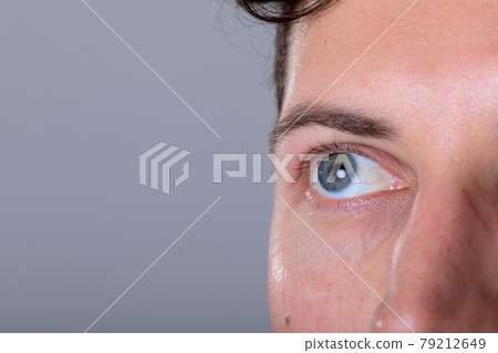 Close up of blue eye of caucasian businessman, isolated on grey background 79212649