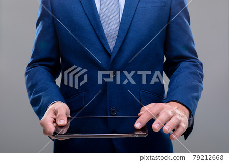 Midsection of caucasian businessman using tablet, isolated on grey background 79212668
