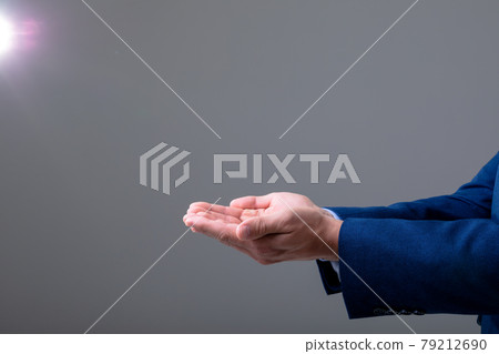Midsection of caucasian businessman showing his hands, isolated on grey background 79212690