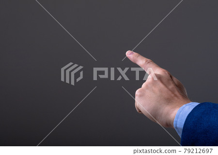 Midsection of caucasian businessman touching virtual interface, isolated on grey background 79212697
