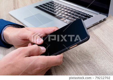 Midsection of caucasian businessman using smartphone and laptop, isolated on grey background 79212702