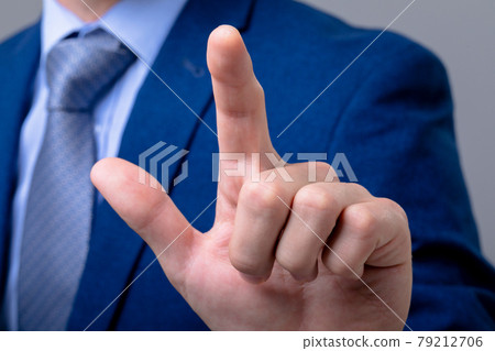 Midsection of caucasian businessman touching virtual interface, isolated on grey background 79212706