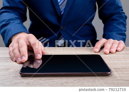 Midsection of caucasian businessman using tablet, isolated on grey background 79212710