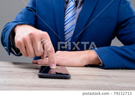 Midsection of caucasian businessman using smartphone, isolated on grey background 79212713