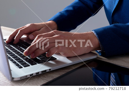 Midsection of caucasian businessman typing on keyboard, isolated on grey background 79212718