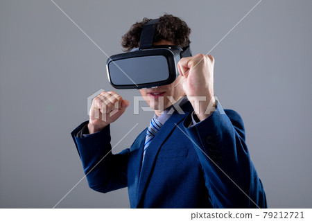 Caucasian businessman wearing vr headset, isolated on grey background 79212721