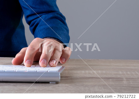 Close up of caucasian businessman typing on keyboard, isolated on grey background 79212722