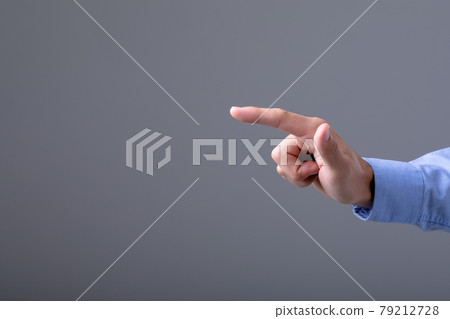 Midsection of caucasian businessman pointing with his finger, isolated on grey background 79212728