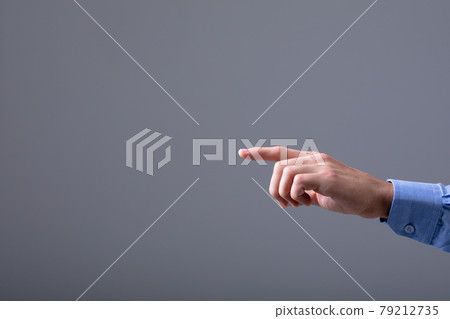 Midsection of caucasian businessman pointing with his finger, isolated on grey background 79212735