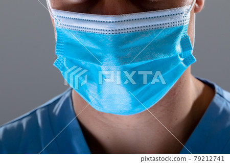 Caucasian male doctor wearing face mask, isolated on grey background 79212741