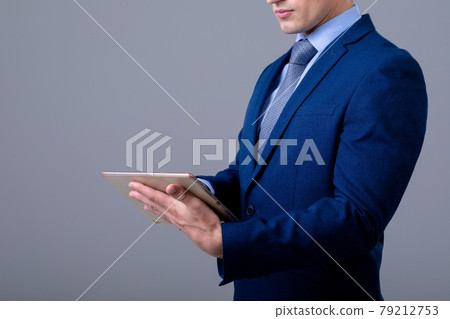 Caucasian businessman using digital tablet, isolated on grey background 79212753
