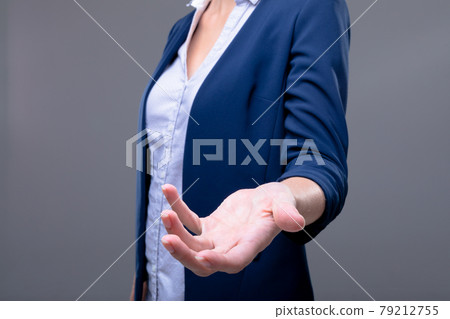 Midsection of caucasian businesswoman reaching with her hand, isolated on grey background 79212755