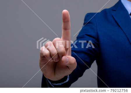Midsection of caucasian businessman touching virtual interface, isolated on grey background 79212756