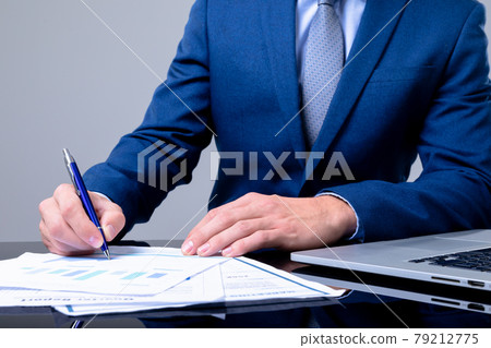 Midsection of caucasian businessman using laptop and taking notes, isolated on grey background 79212775